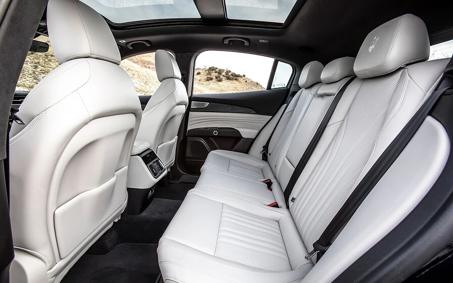 Cabina del Maserati Grecale con asientos blancos bañada por luz natural del techo solar